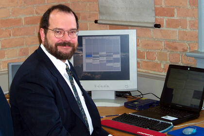 John King sitting at a desk with computers from the late 1990s.
