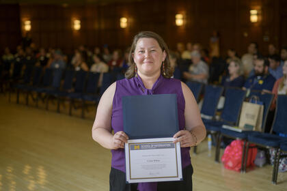 Carina Wilson poses holding an award.
