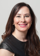 Marta Rey-Babarro sits in front of a gray backdrop