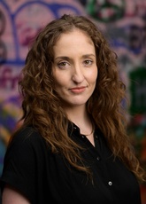Michaelanne Thomas pictured in an alley with colorful graffiti