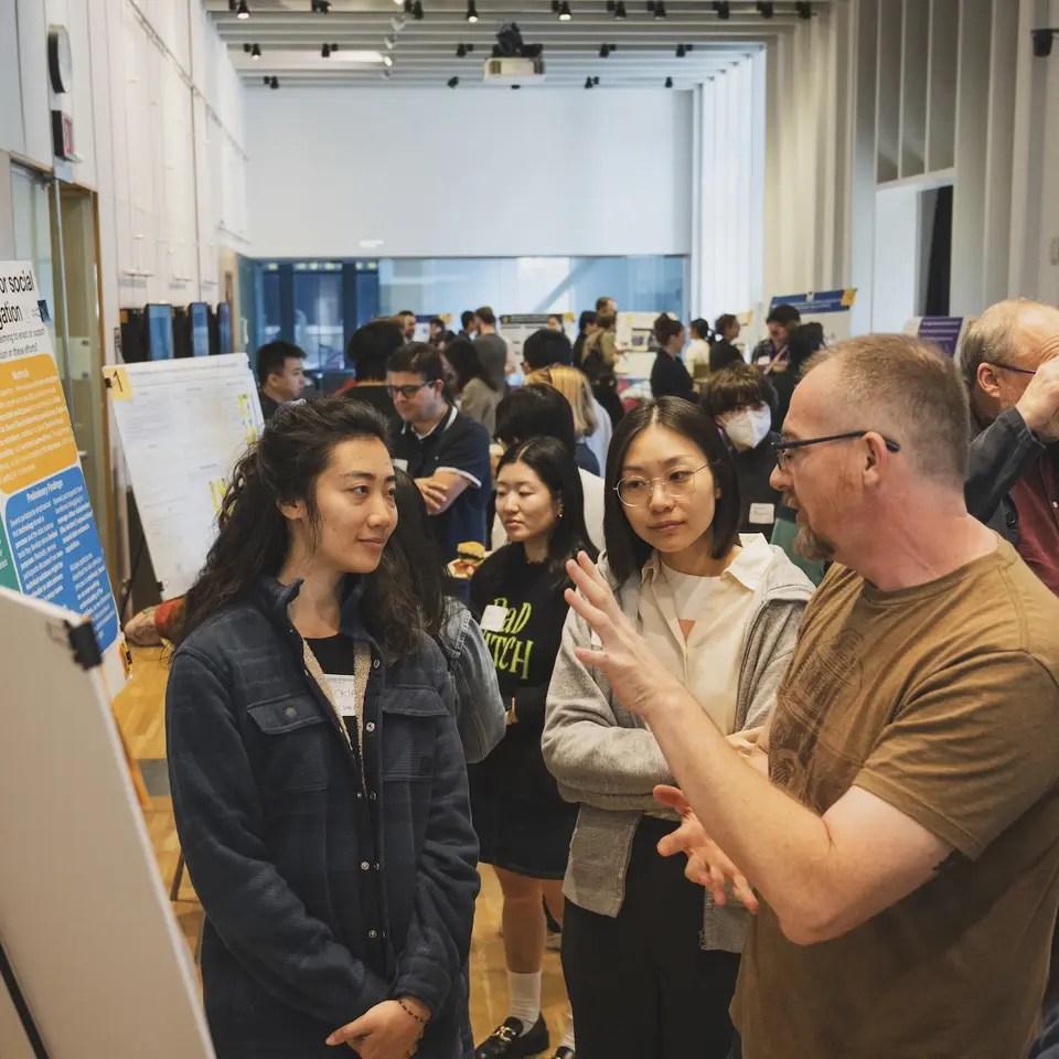 People networking at a poster fair.